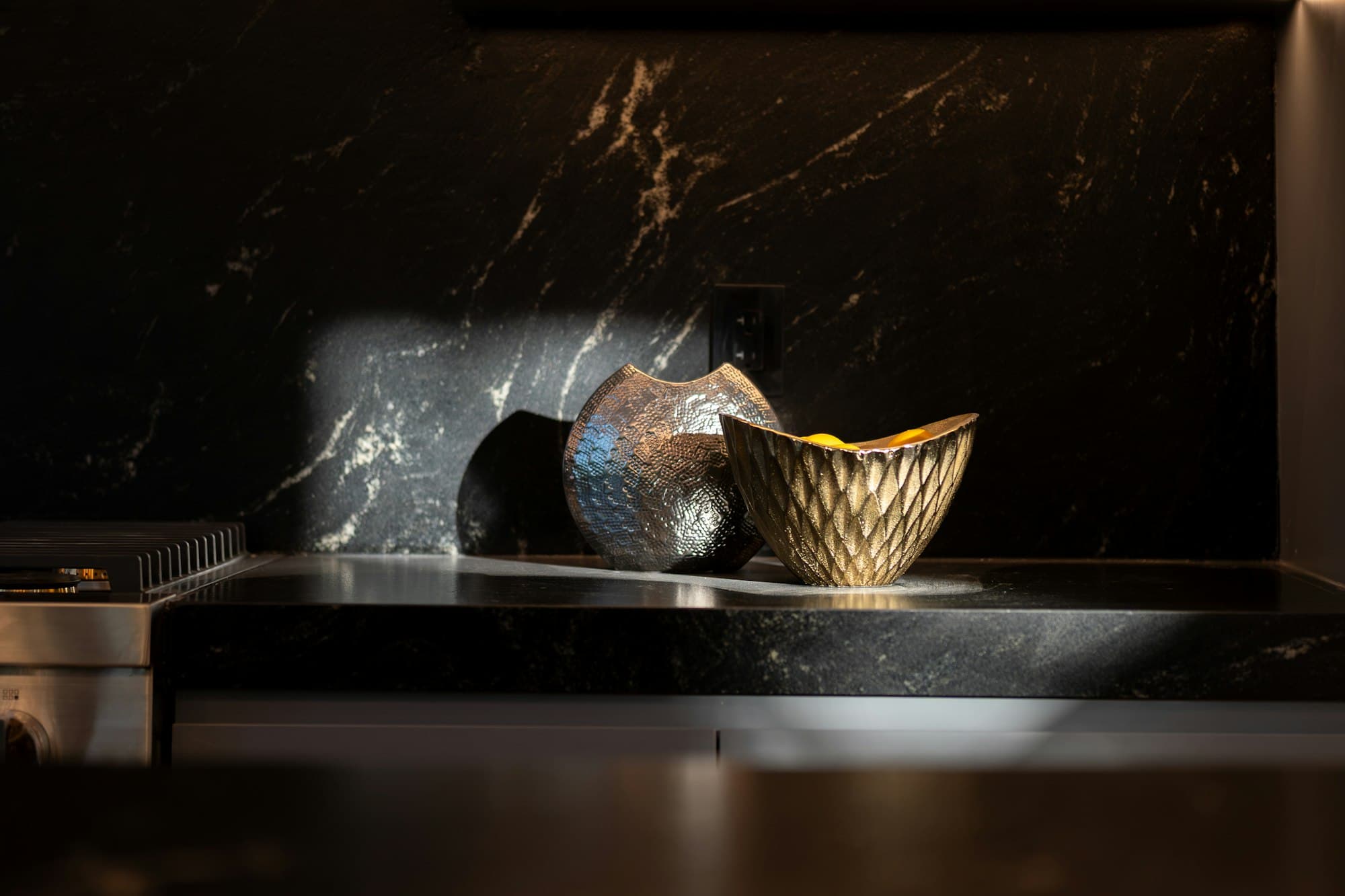 Sculptural bowls on a black marble shelf