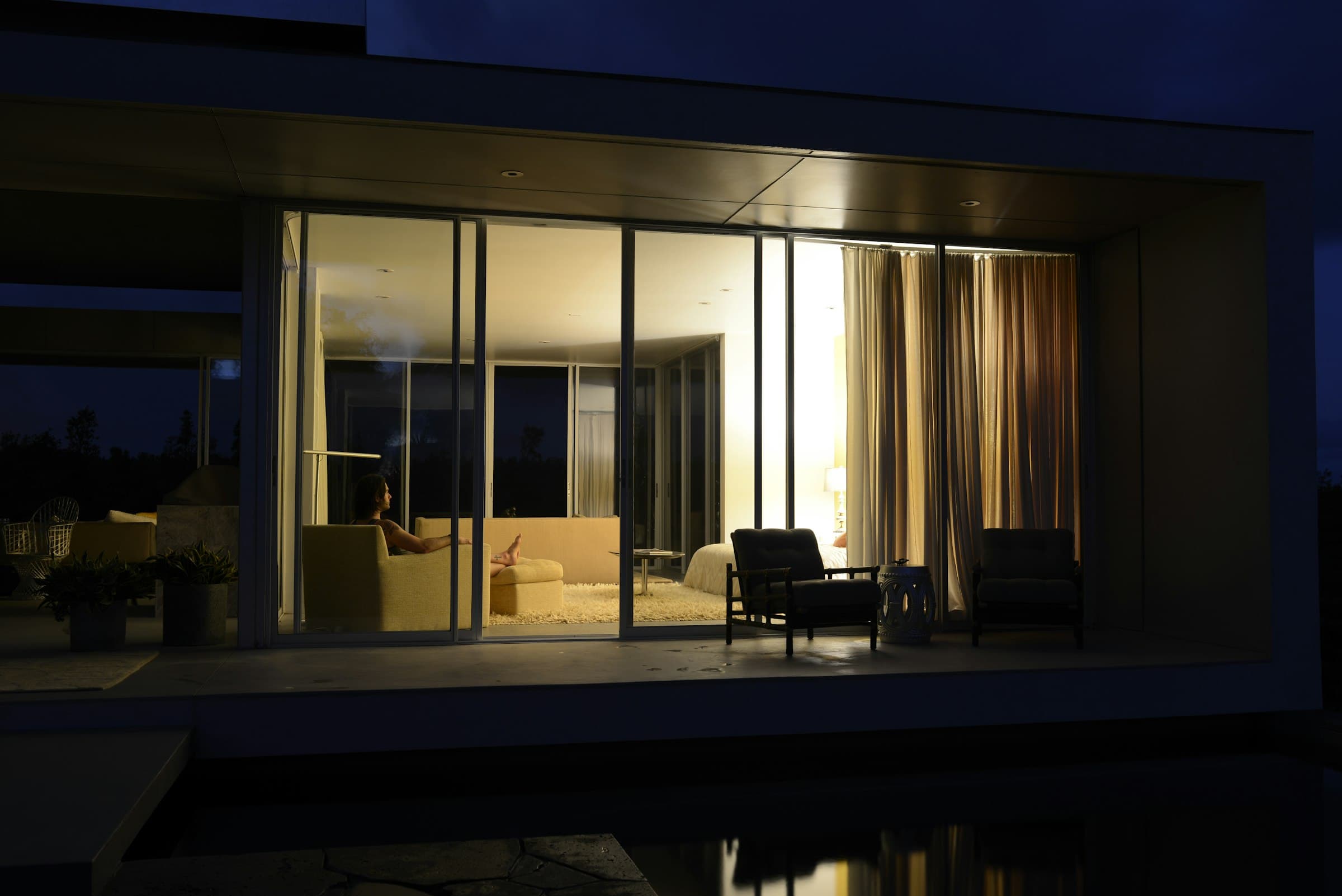 A living room glowing through glass at night
